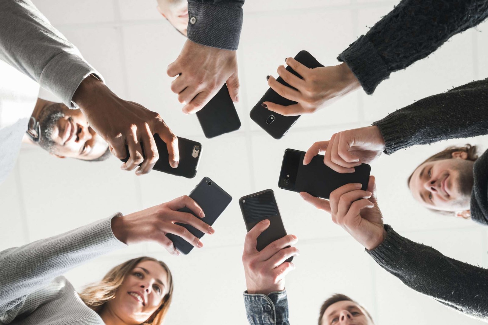 grupo de personas con telefonos celulares formando un circulo